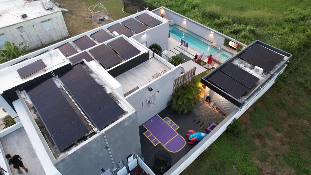 Aerial view of the villa showing rooftop solar panels and pool