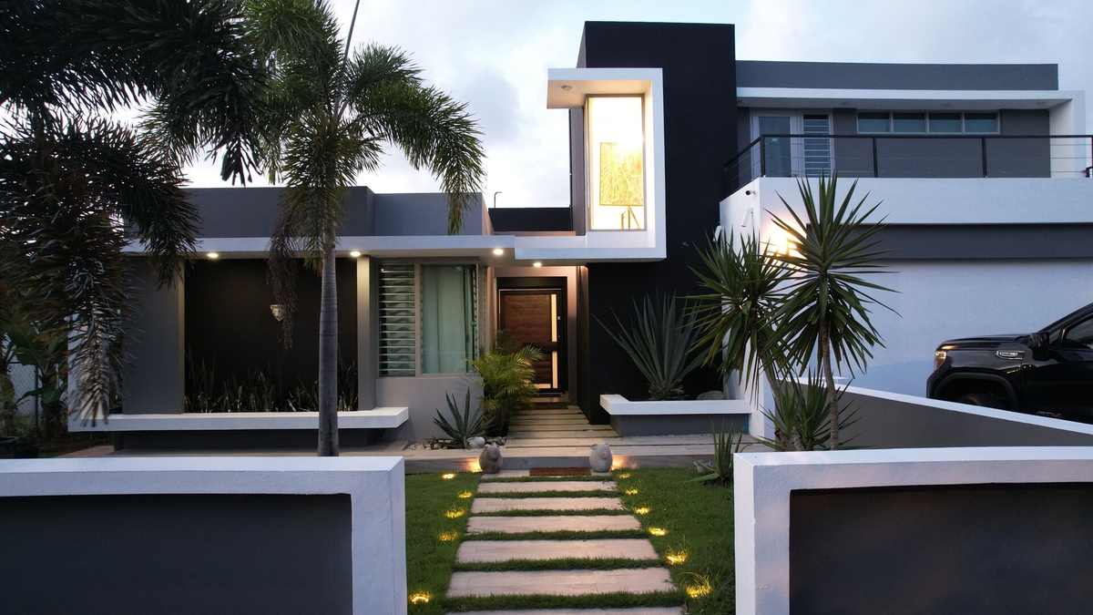 Architectural facade of the villa with landscaped entry path at dusk